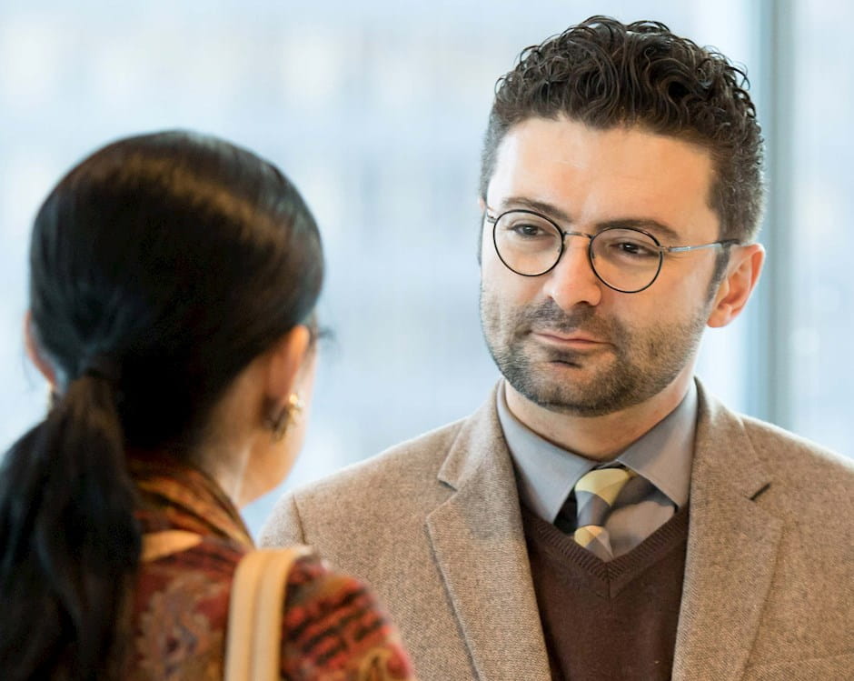 A man speaking to a woman during a Chicago Booth Stigler Center interaction